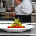 Chef arranging a dish in a professional kitchen